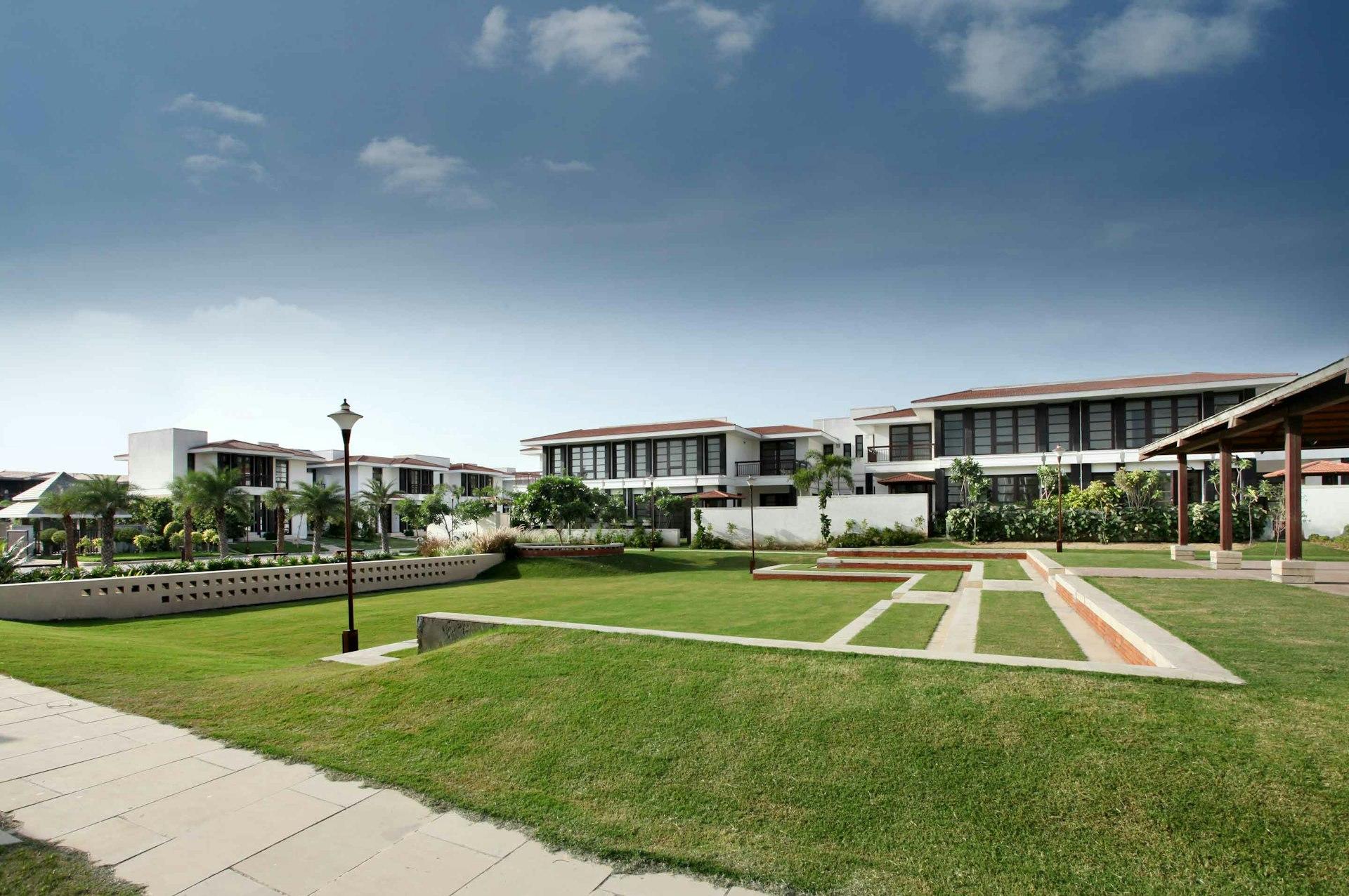 white concrete building near green grass field under blue sky during daytime